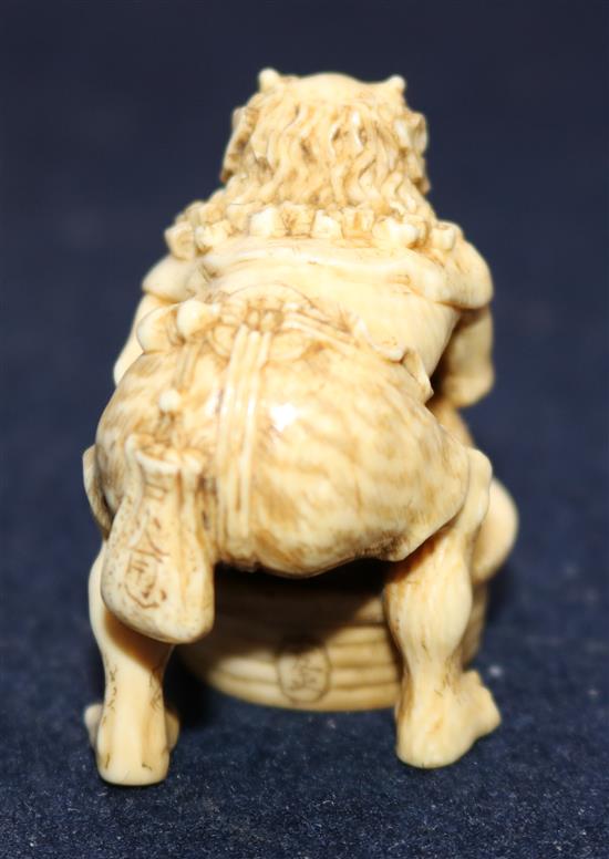 A Japanese ivory netsuke of an oni leaning on a cooking cauldron for rice, signed Tomomasa, 19th century, 4cm, loss to one toe